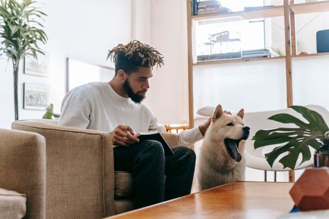 a person sitting on a chair and petting their dog